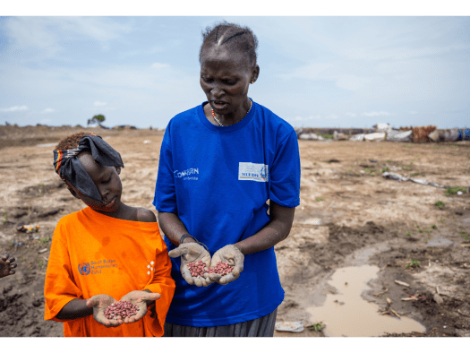 A mother and daughter show in their palms the red bean seeds they are about to plant in the garden plot they are cultivating in Bentiu camp for internally displaced people.