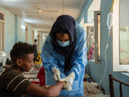 A health worker treats a patient as part of MSF's cholera response in Sudan.