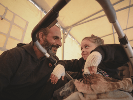 A man smiles at an injured child in Gaza.