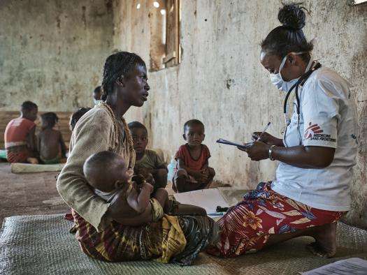 Woman with her child speaking to a medic. 