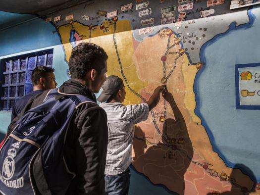 Men check a map at the La 72 migrant shelter in Tenosique, Mexico.